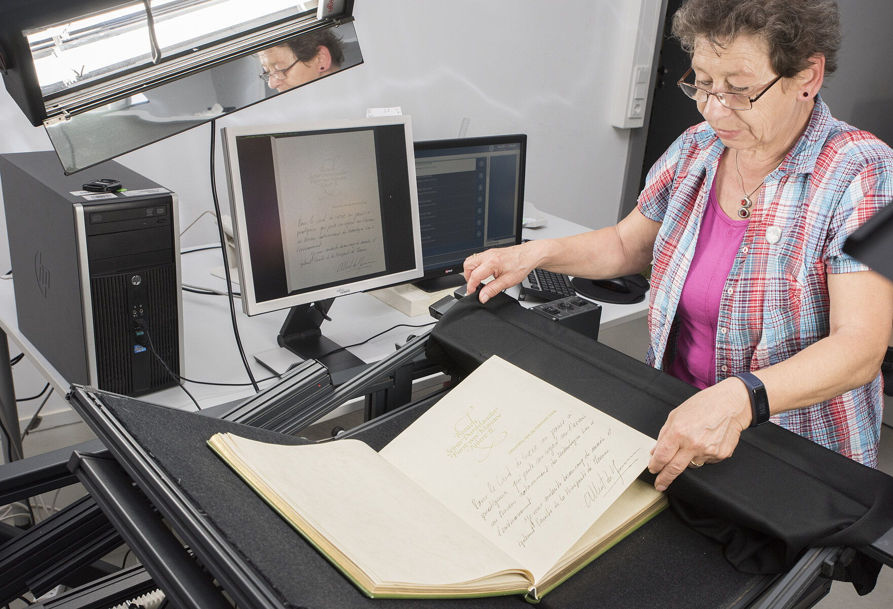 A woman is scanning each page of the guestbook.