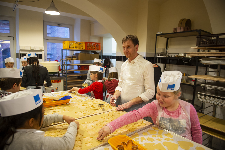 Ein Mann und Kinder backen Plätzchen.