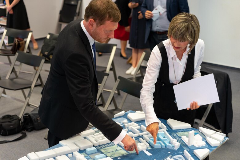 Ein Mann und eine Frau stehen vor einem Modellbau zur Stadtentwicklung.