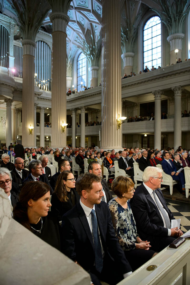 Männer und Frauen sitzen in einer Kirche.