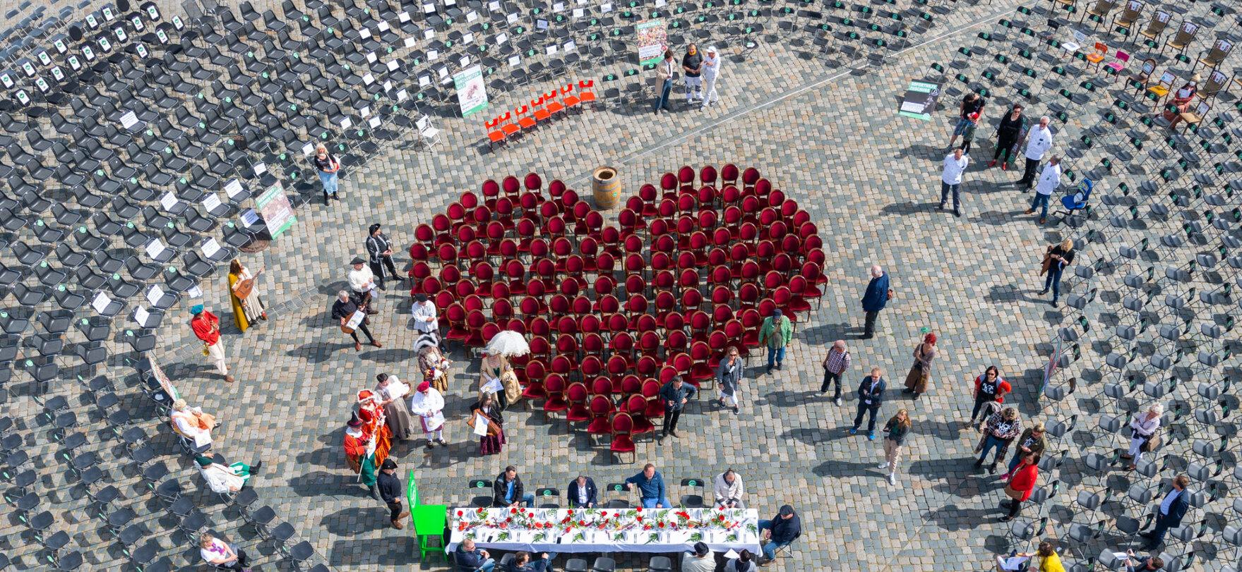 Ein Rotes Herz aus leeren Stühlen auf einem großen Platz.
