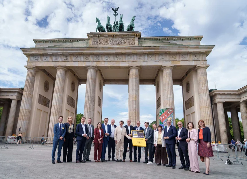 Einige Menschen stehen vor einem alten Bauwerk für ein Gruppenfoto.