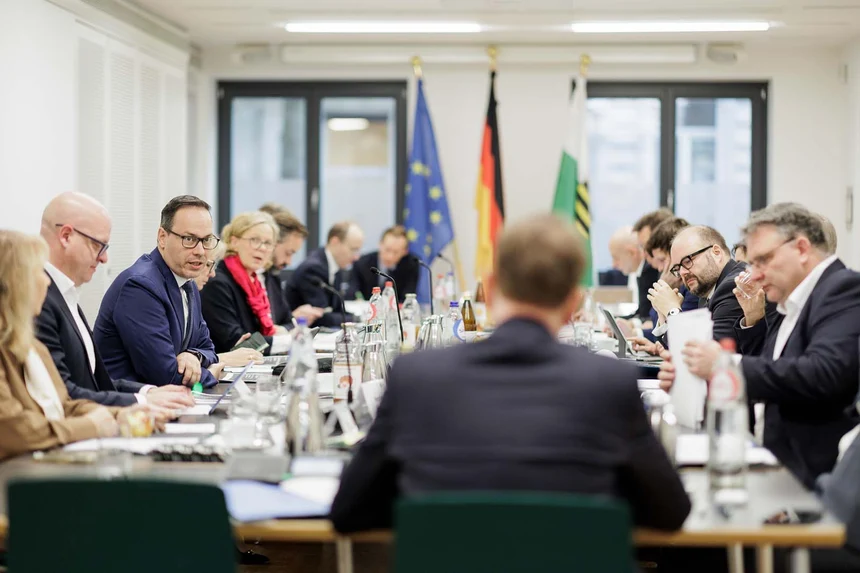 Ein Konferenztisch ist besetzt von verschiedenen Personen.