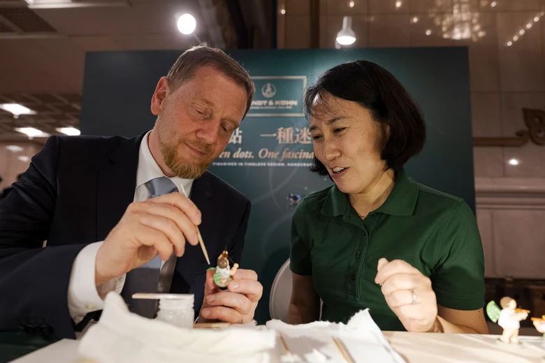 Ein Mann und eine Frau bemalen einen Engel der Firma Wendt und Kühn.