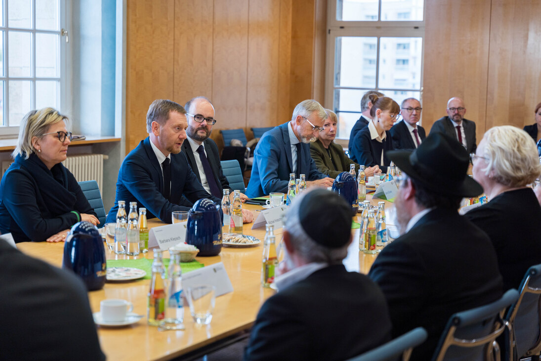 Mehrere Personen sitzen an einem Konferenztisch.