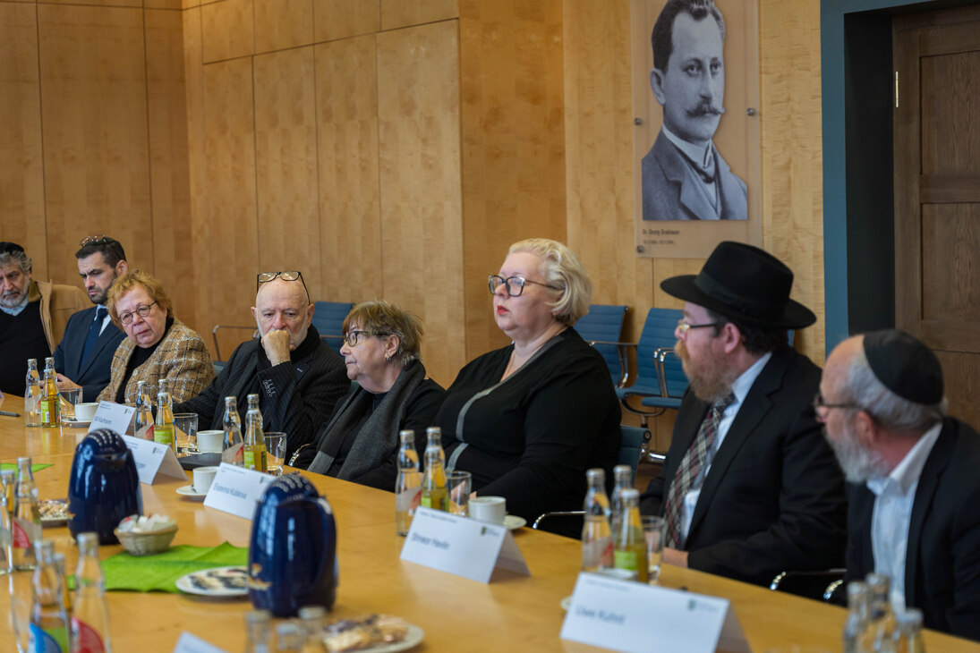 Mehrere Personen sitzen an einem Konferenztisch.