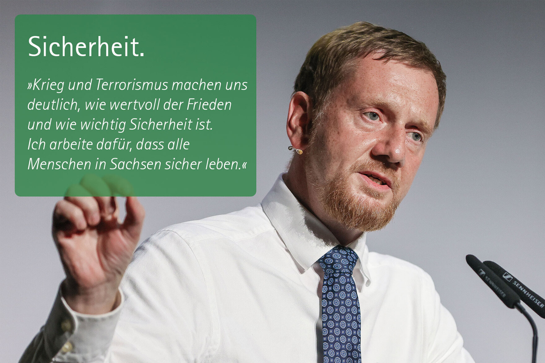 Ein Mann. Zitat: Sicherheit. »Mir ist es deshalb wichtig, Polizei und Justiz, Feuerwehr und Zivilschutz weiter zu stärken. Es braucht einen starken Antritt gegen Extremismus jeder Art. Und es ist gut, dass die Bundeswehr künftig in Sachsen durch einen neu
