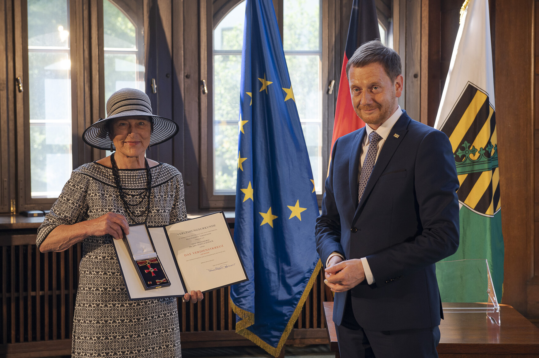 Eine Frau hält eine Urkunde in der Hand.