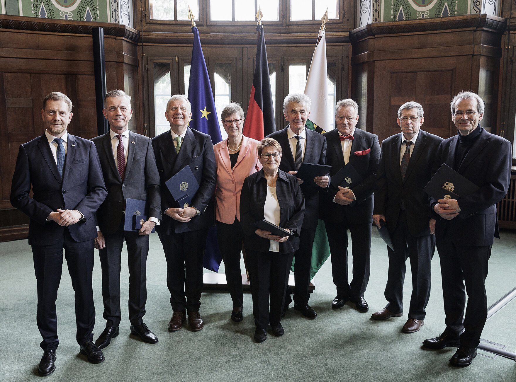 Männer und Frauen stehen in einer Gruppe für ein Foto zusammen.