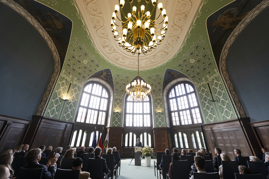 Ein Mann steht in einem großen Saal an einem Rednerpult. Vor ihm sitzen viele Menschen.