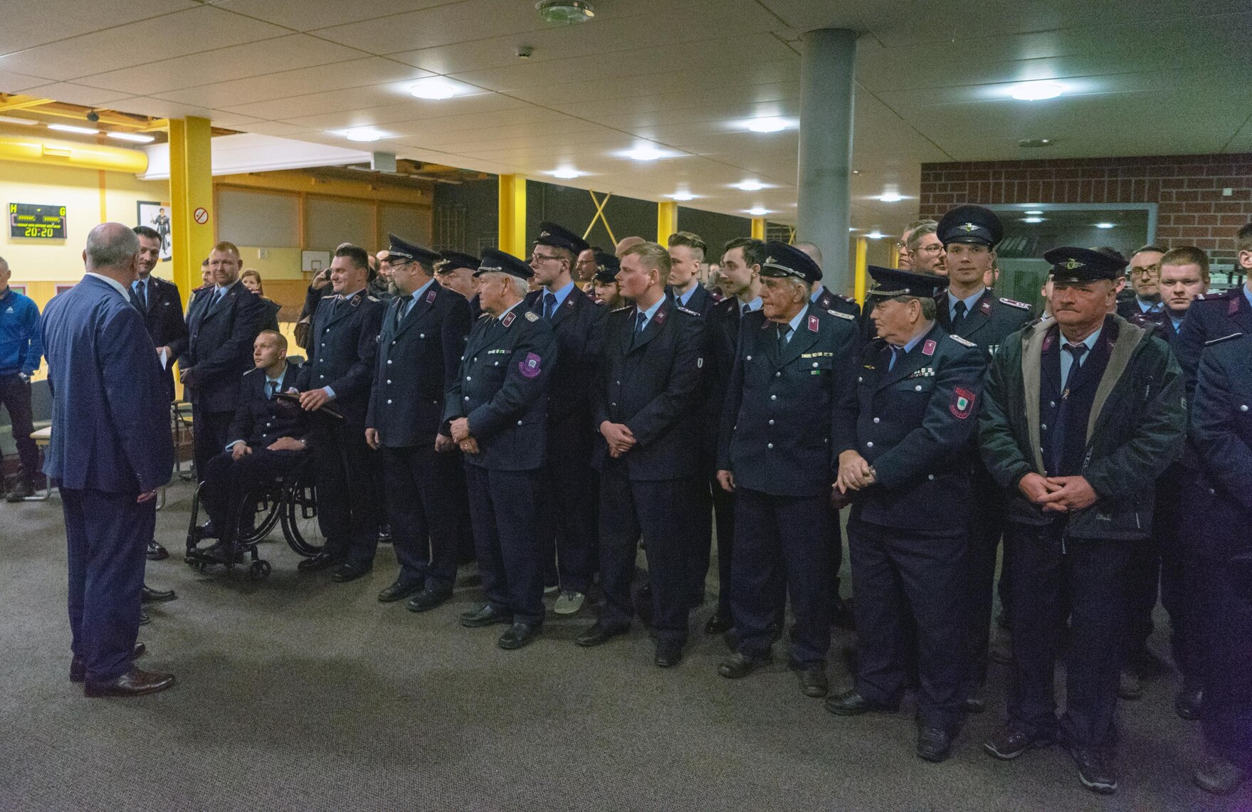 Feuerwehrmänner stehen Spalier vor einem Mann.