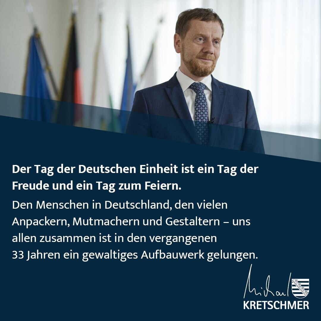 Ein Mann steht vor einer Fahnengalerie.