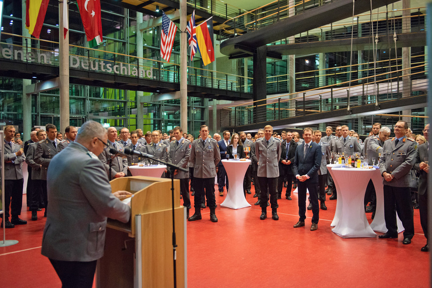 Soldatinnen und Soldaten sind in einer grpßen Halle versammelt.