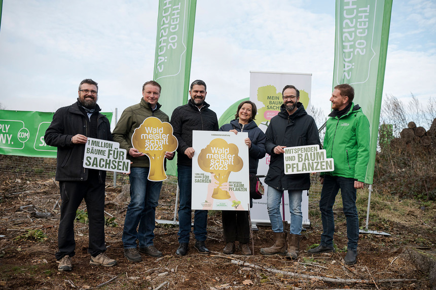 Männer und Frauen halten Plakate in der Hand.