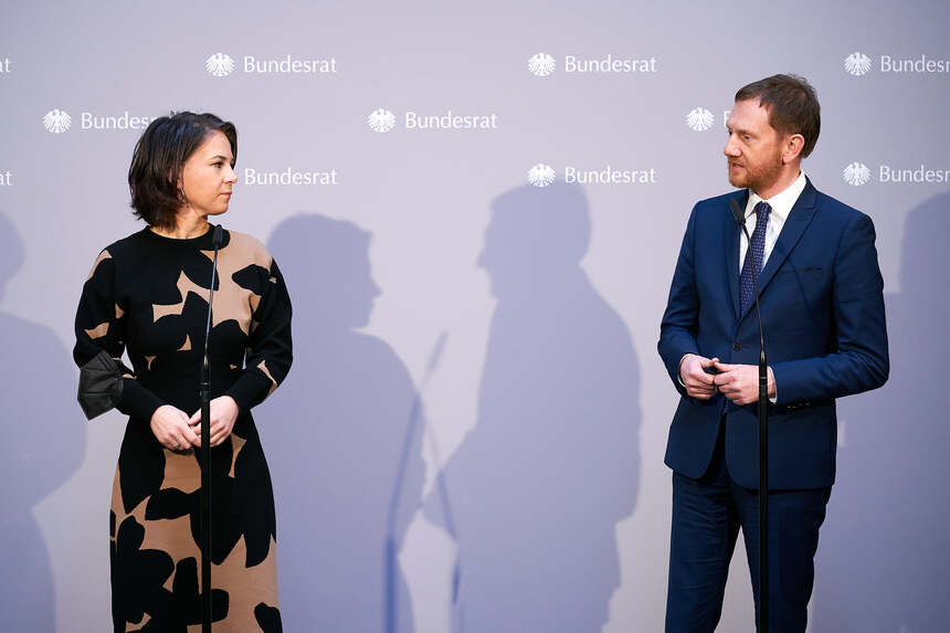 Ein Mann und eine Frau stehen vor einer Presseleinwand.