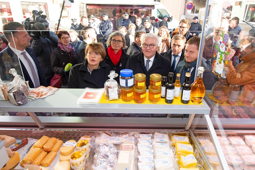 Männer und Frauen stehen vor der Theke eines Verkaufswagens.