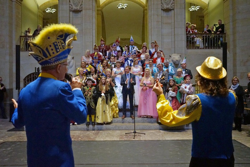 Männer und Frauen in Fachingskleidung stehen in der Halle eines alten Gebäudes.