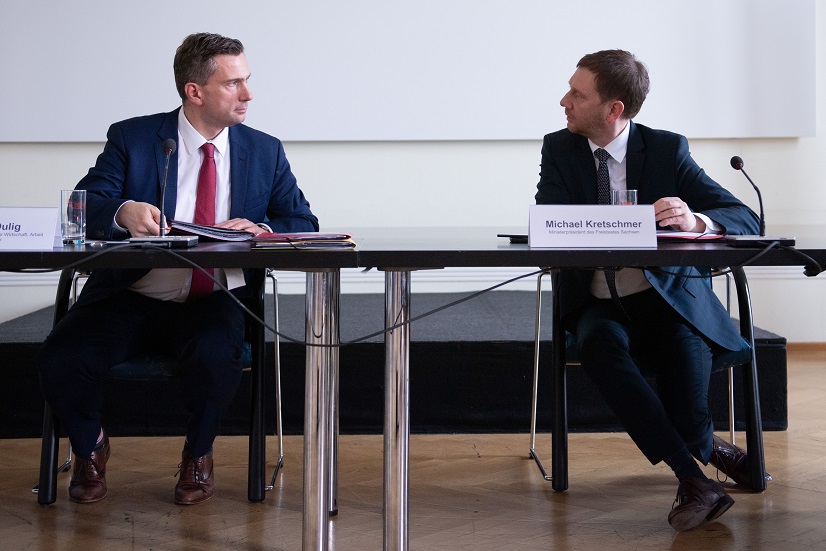 Zwei Männer sitzen an einem Tisch.