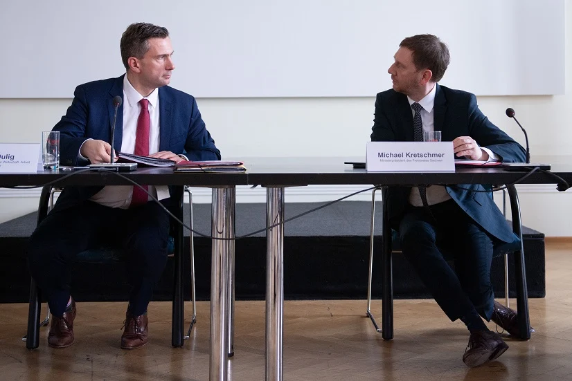 Zwei Männer sitzen an einem Tisch.