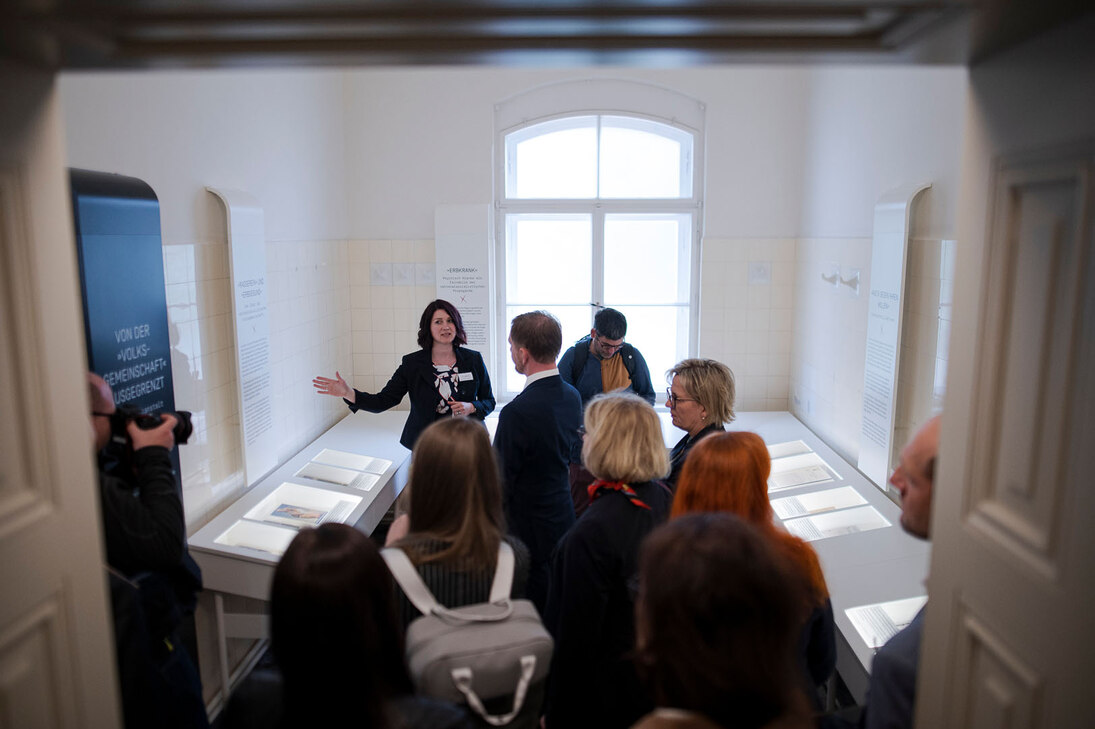 Männer und Frauen besichtigen eine Ausstellung.