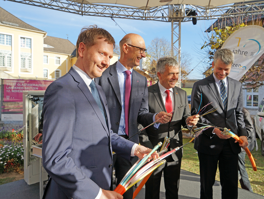 Männer halten Glasfaserkabel in der Hand.