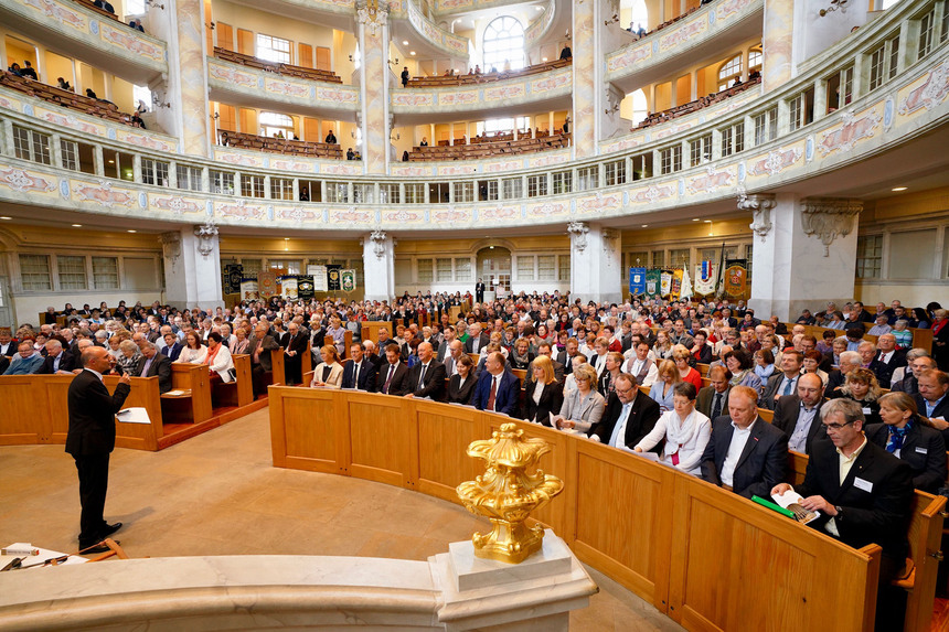 Männer und Frauen sitzen in einer Kirche