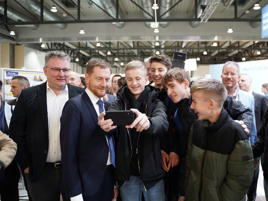 Ein Mann macht mit jungen Männern ein Selfie.