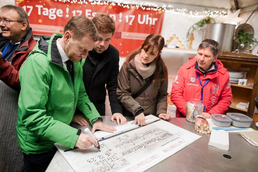 Ein Mann füllt einen großen Spendenschein aus.