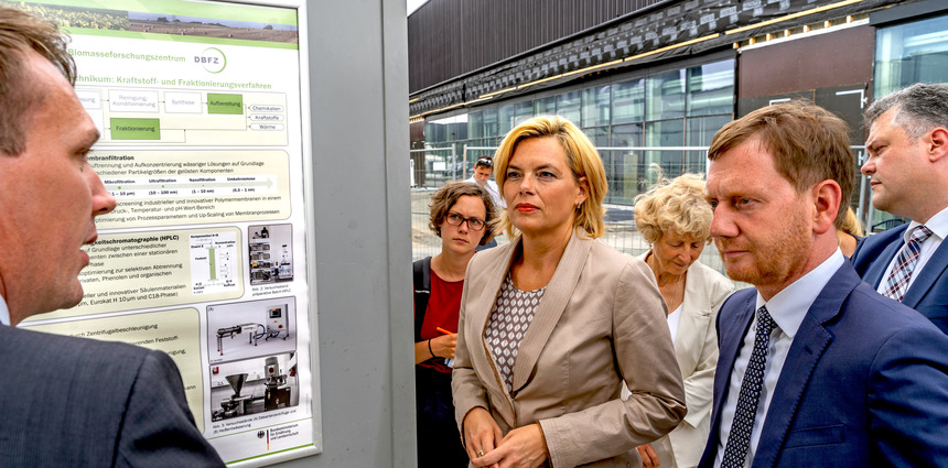 Ein Mann und eine Frau hören einer Präsentation eines Mannes zu.