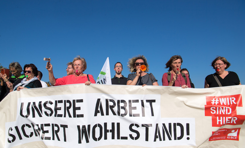 Demonstranten halten ein Banner in der Hand.