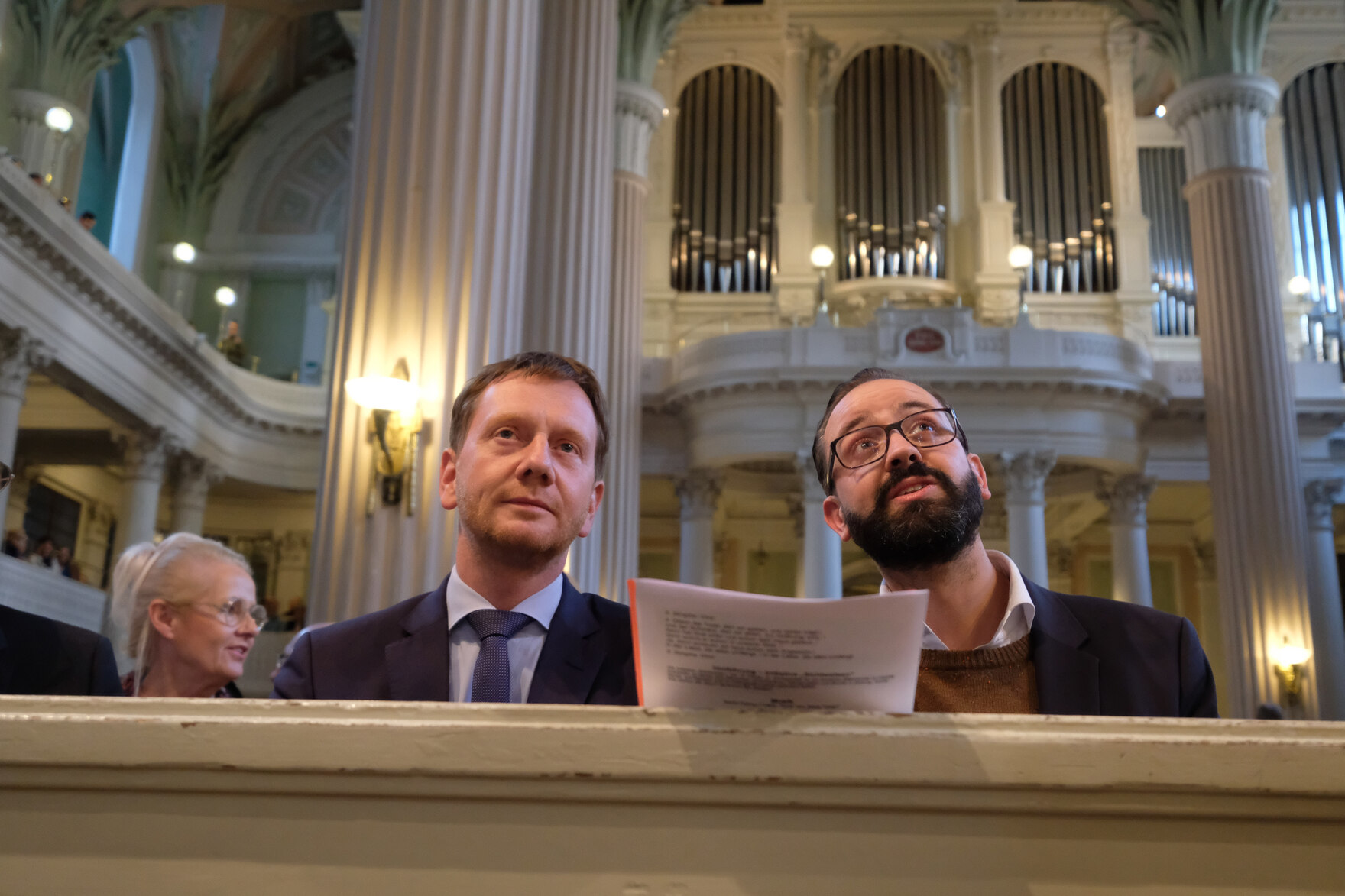 Zwei Männer sitzen auf einer Kirchenbank.