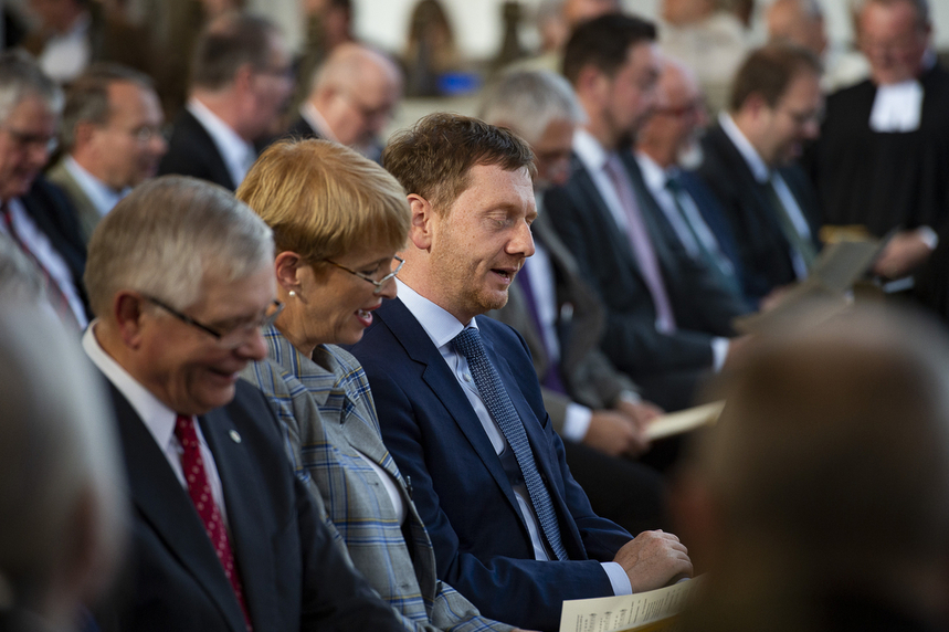 Männer und Frauen singen in einer Kirche.