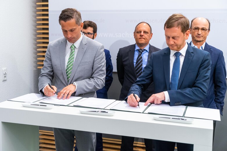 Zwei Mänbner unterzeichnen einen Vertrag.