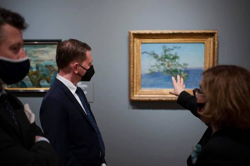 Ein Mann und eine Frau betrachten ein Gemälde.