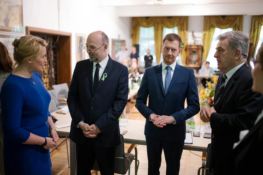 Männer und Frauen stehen nebeneinander und unterhalten sich.