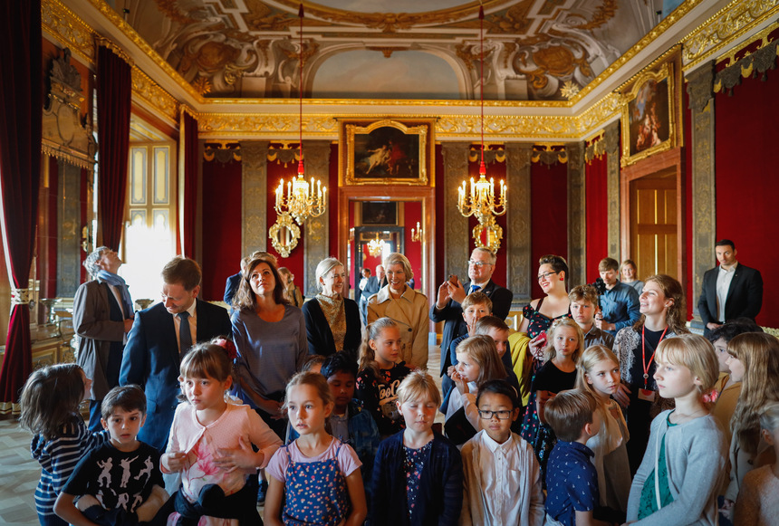 Männer und Frauen stehen in einem Punksaal mit Kindern zusammen.