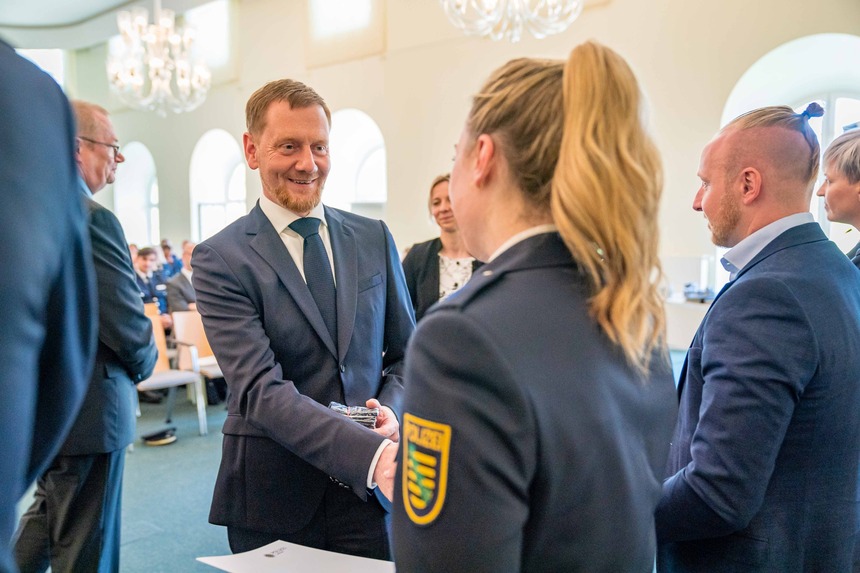 Ein Mann reicht einer Polizistin die Hand.