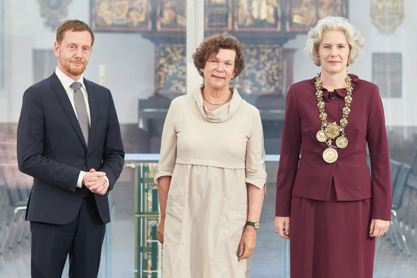 Ein Mann steht neben zwei Frauen.