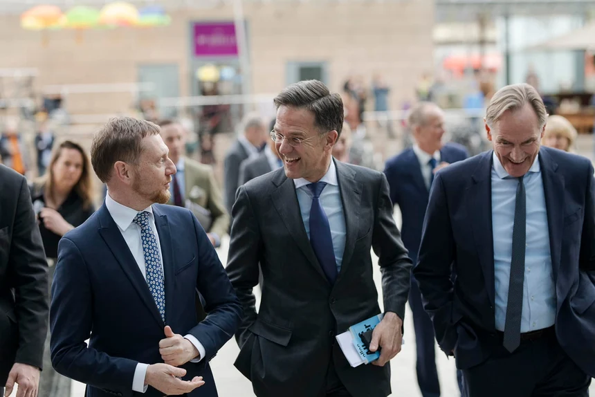 Drei Männer gehen zusammen und unterhalten sich.