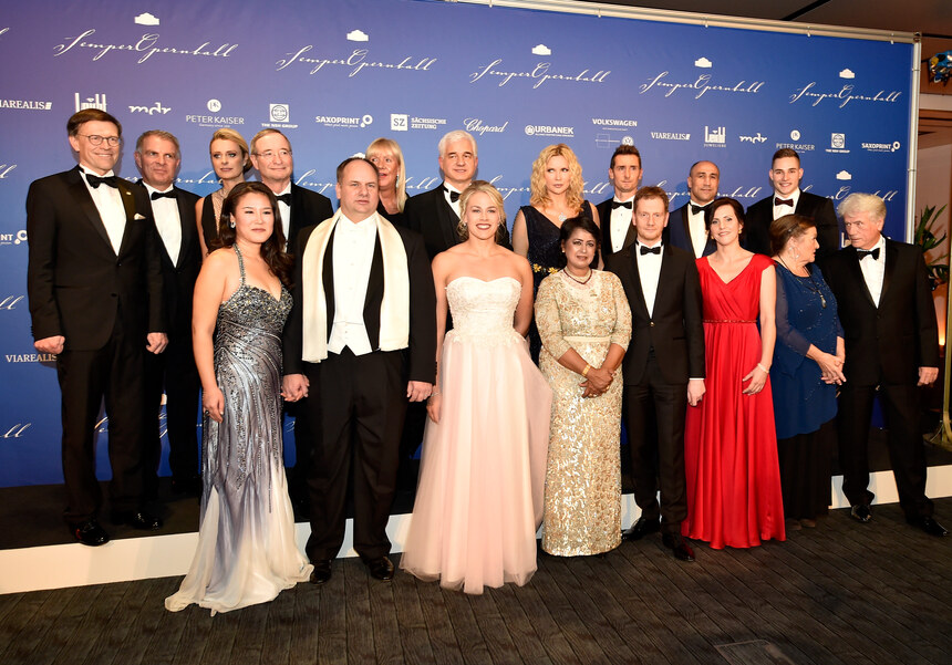 Männer und Frauen stehen in Reihe und posieren für ein Foto.