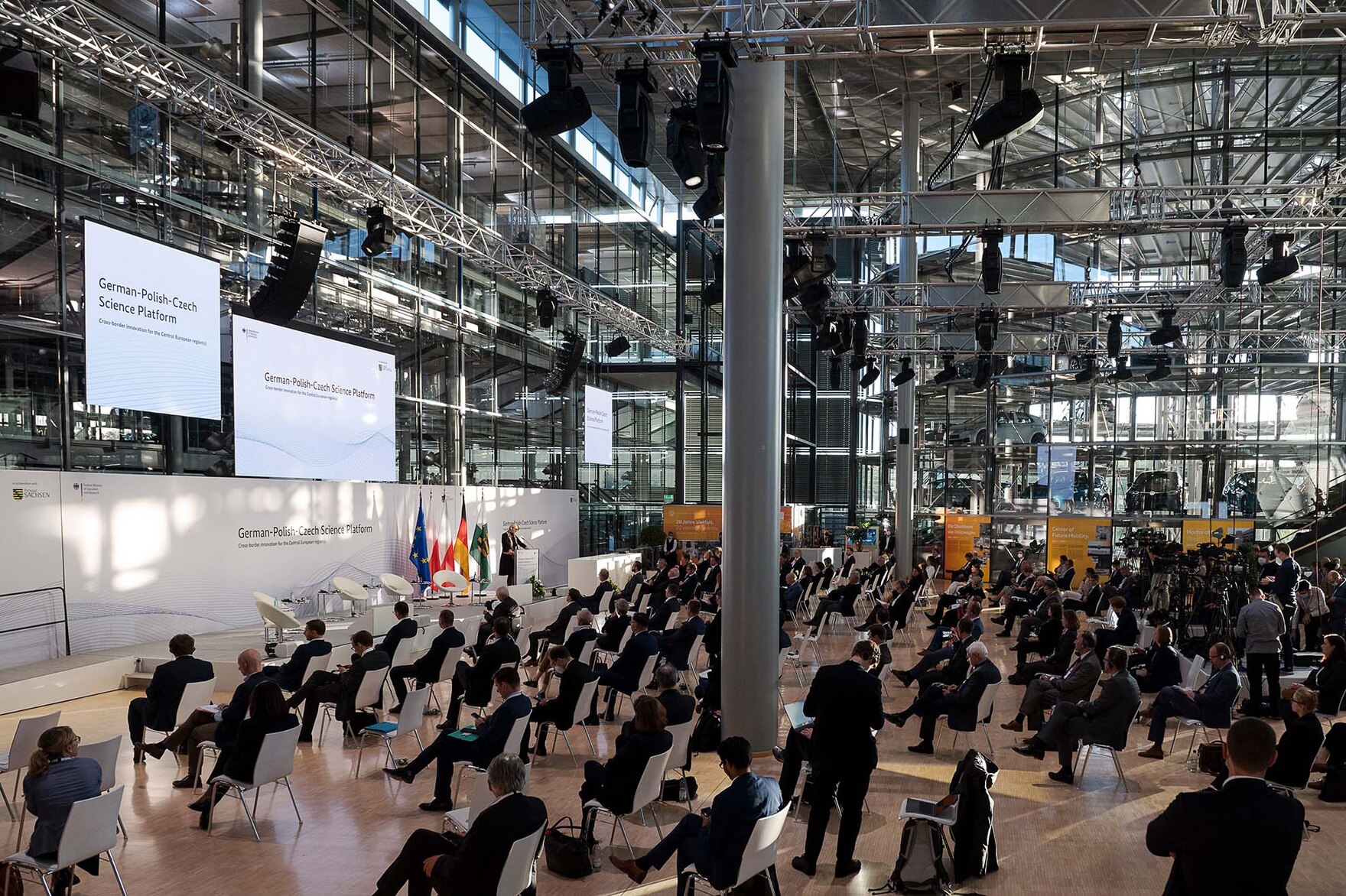 In einer großen Halle sitzen Menschen während einer Konferenz.