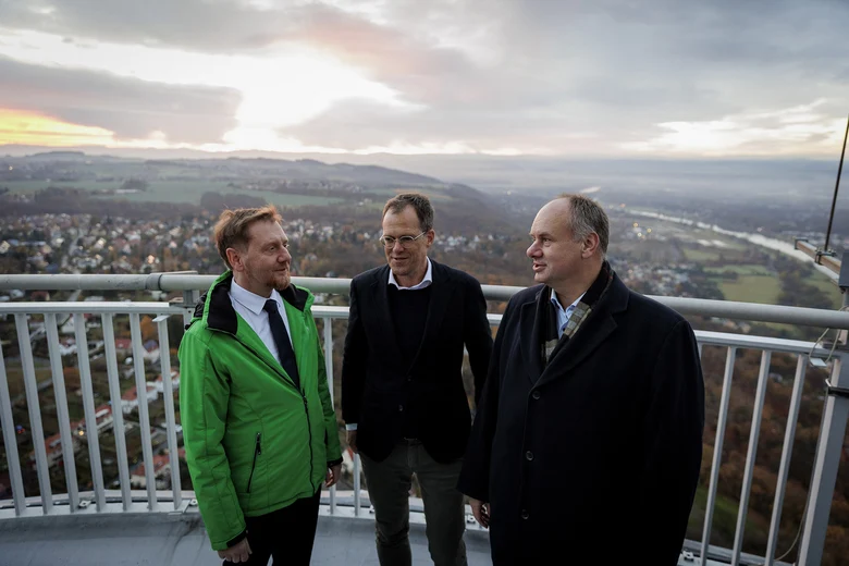 Drei Männer stehen auf einer Aussichtsplattform.
