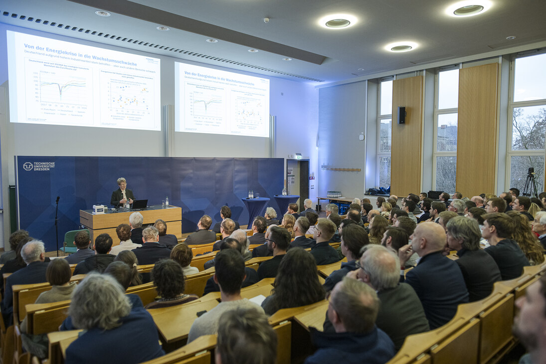 Eine Frau führt eine Präsentation in einem Uni-Hörsaal durch.