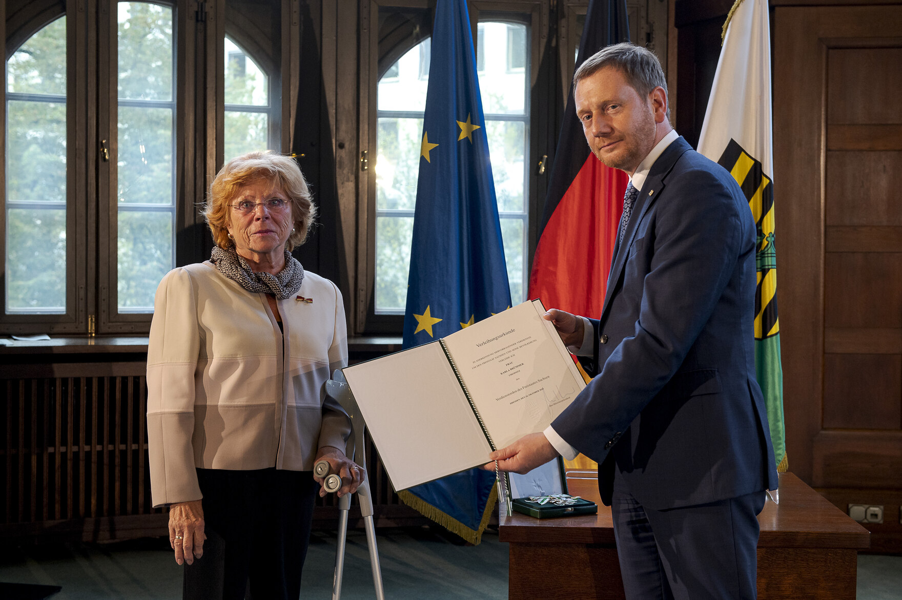 Ein Mann und eine Frau halten einen Orden in der Hand.