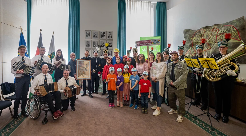 Männer, Frauen und Kinder stehen in einer Gruppe zusammen und posieren für ein Foto.