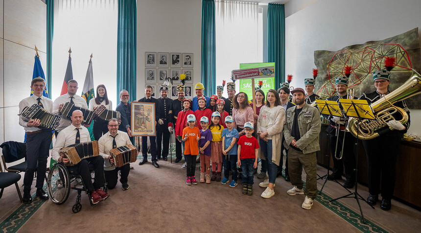 Männer, Frauen und Kinder stehen in einer Gruppe zusammen und posieren für ein Foto.