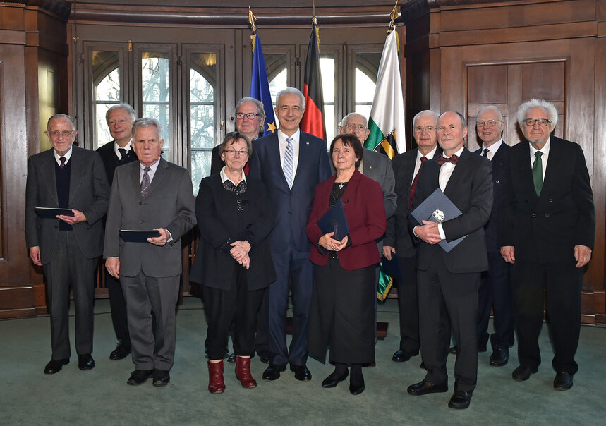 Eine Gruppe von Menschen posiert in einem Saal für ein Foto.