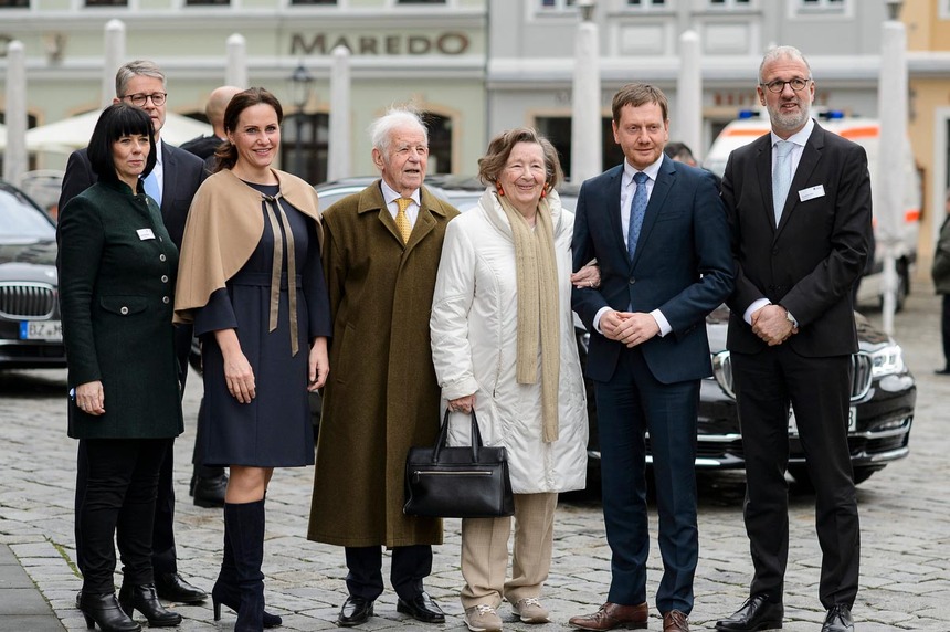 Männer und Frauen stehen auf einem großen Platz.