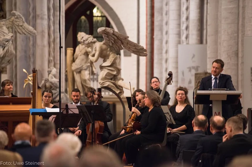 Ein Mann steht an einem Rednerpult in einer Kirche.