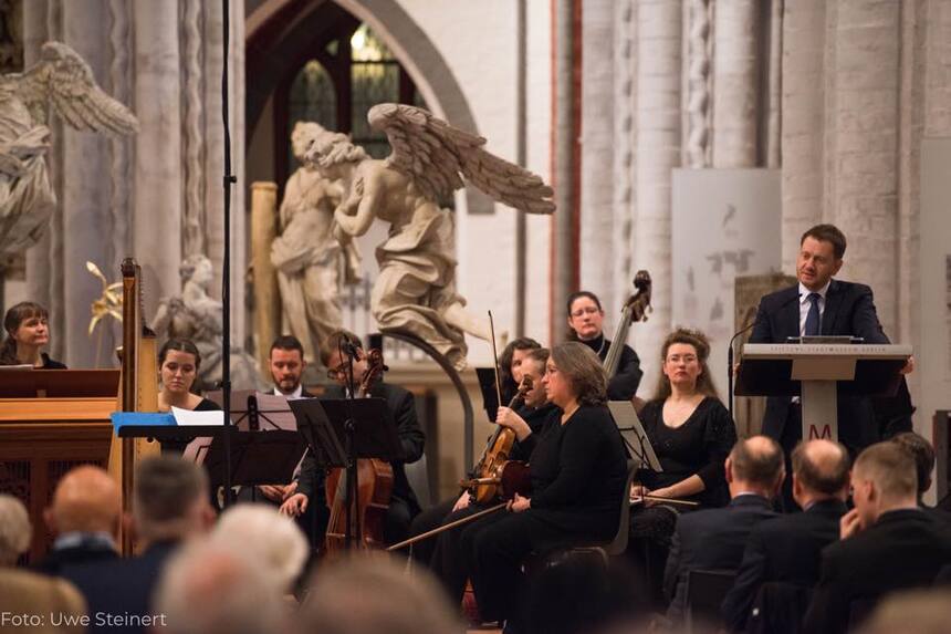 Ein Mann steht an einem Rednerpult in einer Kirche.